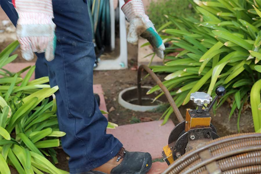 Plumber performing drain cleaning