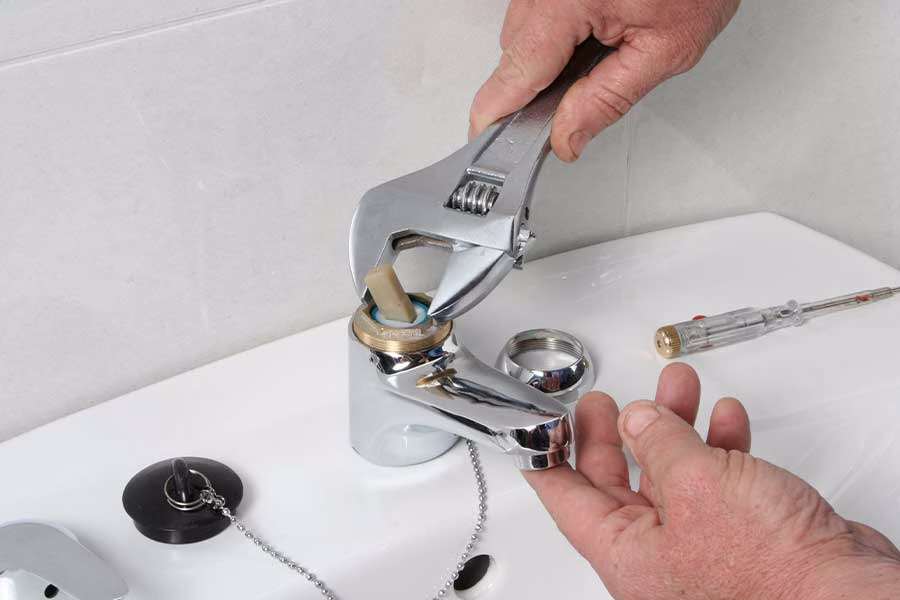 Plumber repairing faucet