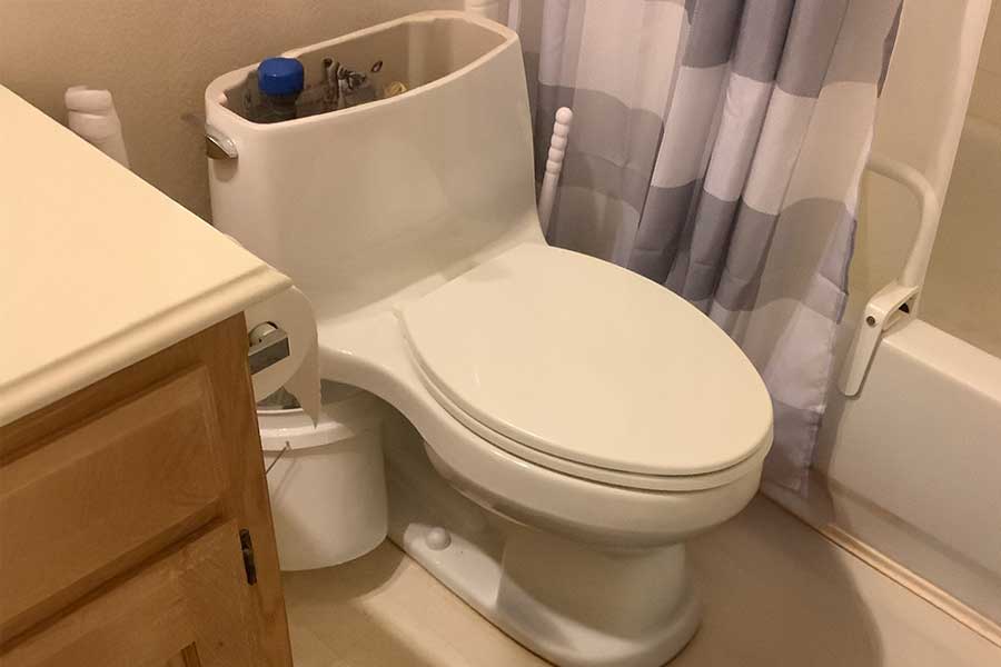 Plumber fixing or replacing toilet