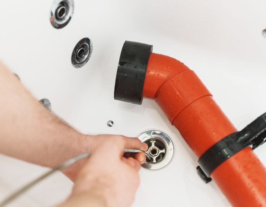 Plumber using drain snake